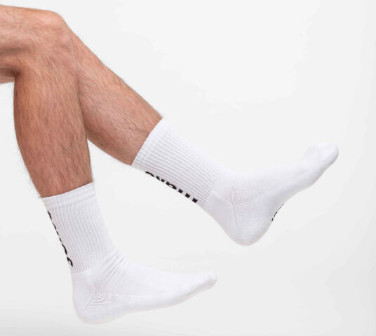 Woman wearing white socks close up two feet from behind.