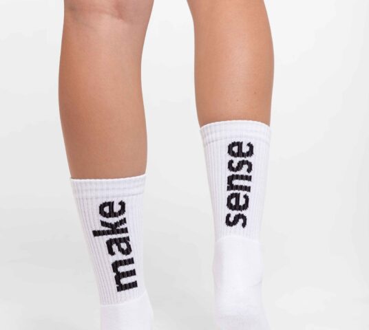 Woman wearing white socks close up two feet from behind.