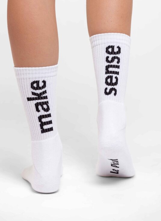 Woman wearing white socks close up two feet from behind.